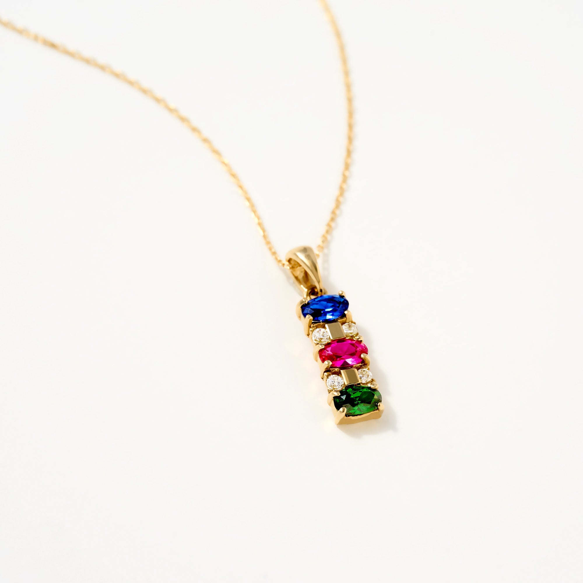 14K Gold Multi-Gemstone Pendant Necklace with sapphire, ruby, emerald, and diamonds on a gold chain.